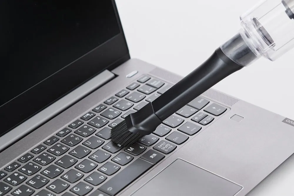 ノートパソコンのキーボードを掃除機で掃除している様子