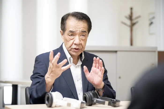 テーブルの前に座って話をしている男性の画像