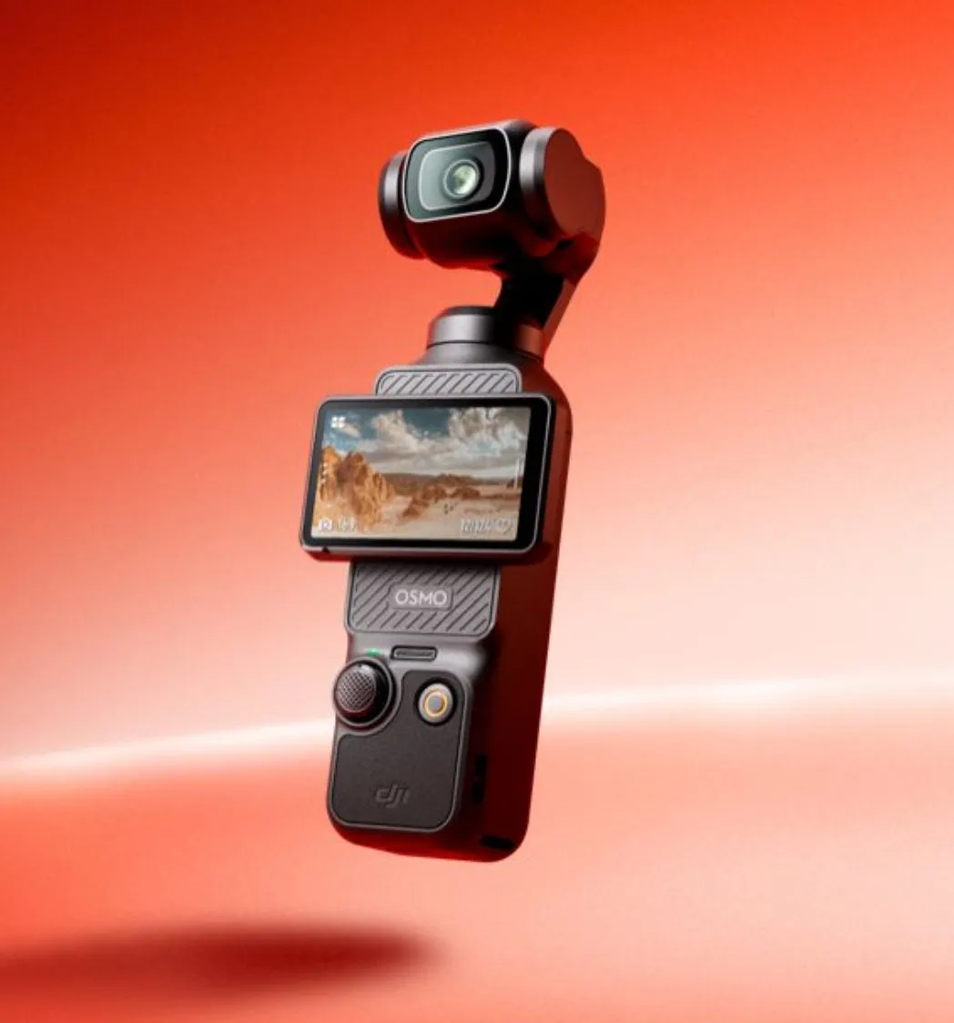 DJI Osmo Pocketカメラのクローズアップ写真。カメラは黒色で、画面に風景が表示されています。背景は赤色。