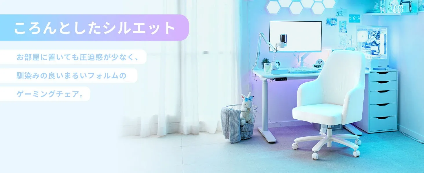 白いゲーミングチェアが置かれた、おしゃれな書斎の様子が写っています。デスクの上にはモニターやスピーカー、観葉植物などが置かれ、窓からは光が差し込んでいます。