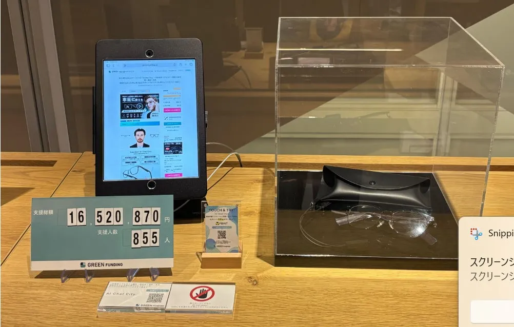 眼鏡店内の様子。タブレット、眼鏡、支援額を示す表示などが見える。