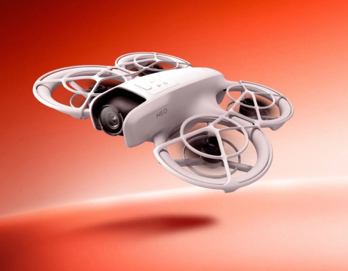 白いドローンが、オレンジ色の背景に浮かんでいる様子。NEO