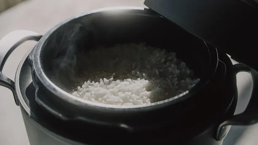 炊飯器で炊かれたご飯のクローズアップ写真。ご飯から湯気が立っている。