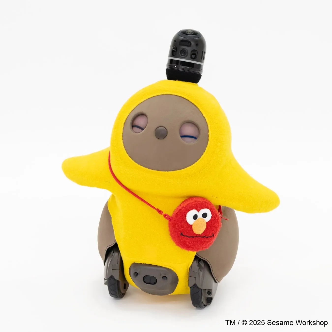 セサミストリートのキャラクター、エルモを模した黄色いカバーを装着したロボット。ロボットは車輪で移動し、頭部にはカメラのようなものが搭載されている。カバーにはエルモの顔が描かれた赤いポーチが取り付けられている。