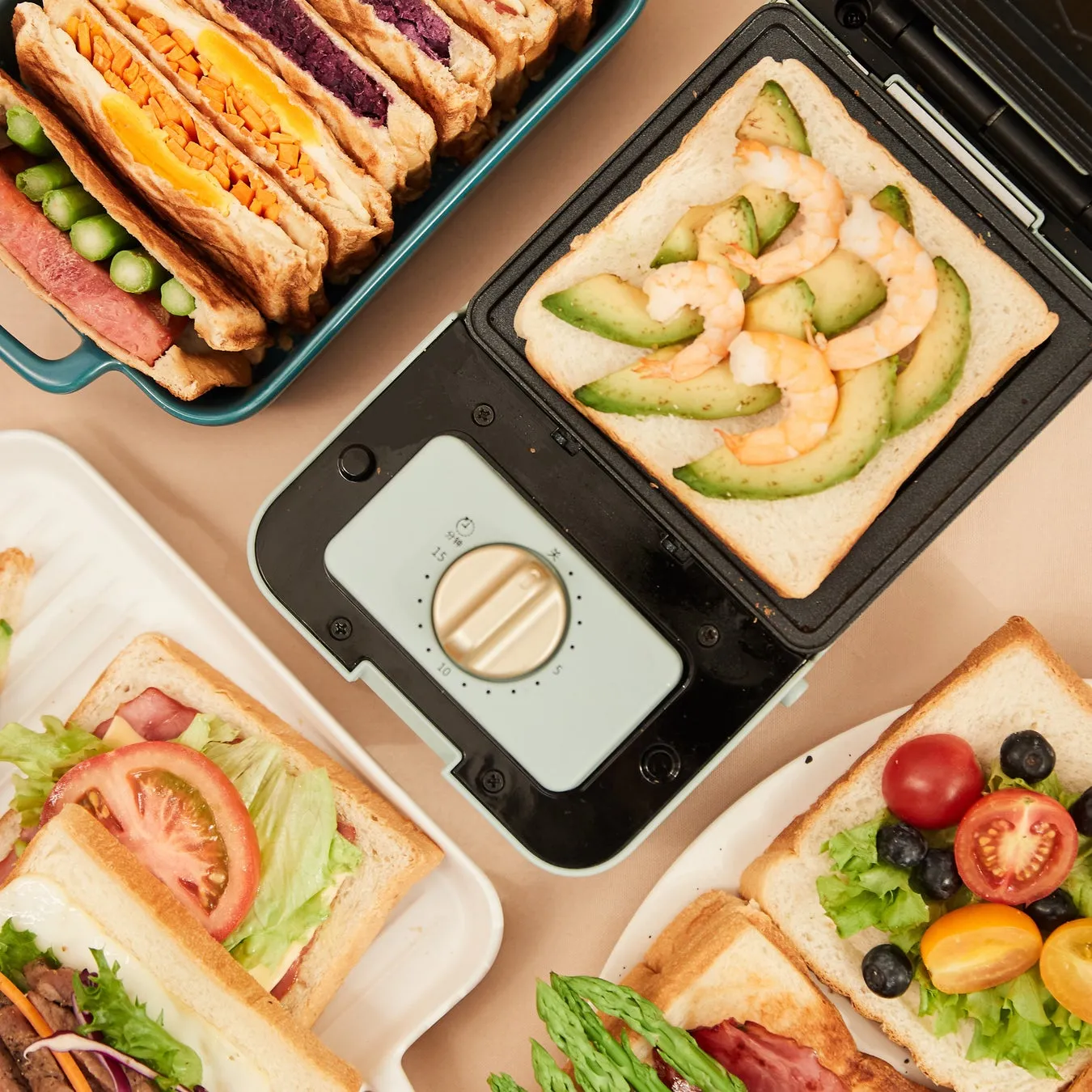 様々な具材を挟んだサンドイッチとサンドメーカーを俯瞰で捉えた写真。アボカドとエビ、トマト、レタス、アスパラガスなど、彩り豊かな具材が目を引く。色とりどりのサンドイッチが食欲をそそる。