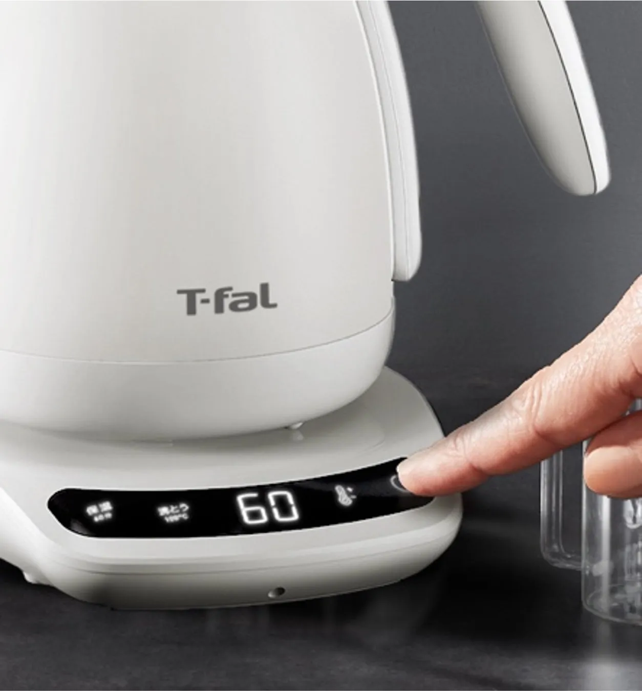T-falの電気ケトル。温度が表示され、指でボタンを押している様子。