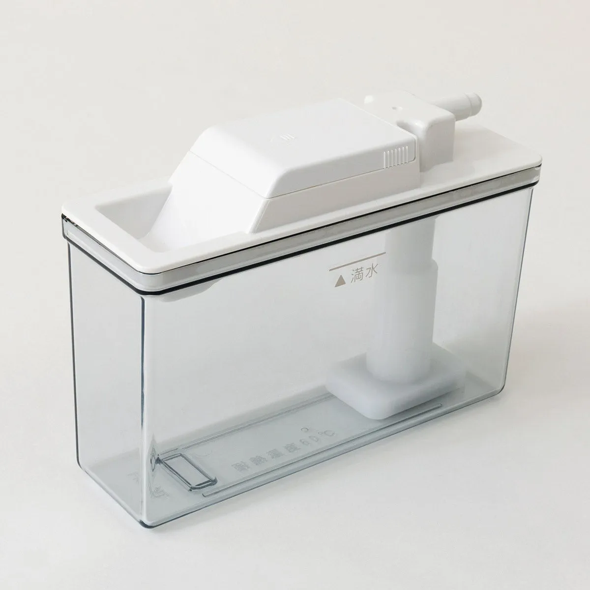 透明な容器に白い蓋と内部構造が組み込まれた製品の写真。蓋には注入口のような突起があり、「満水」の文字とマークが見える。製品の側面には「耐熱温度60℃」と記載。