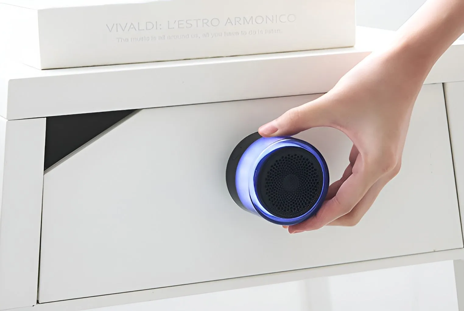 手で持たれた青色のライト付きスピーカー