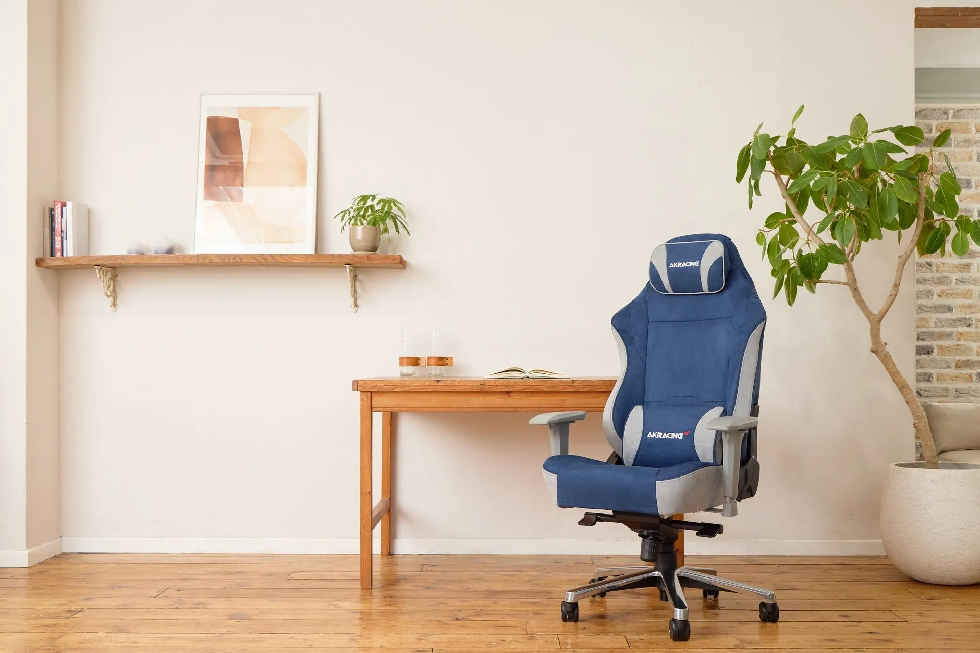 青色のゲーミングチェアが置かれた部屋の写真です。木製の机や棚、観葉植物があり、シンプルで落ち着いた雰囲気です。