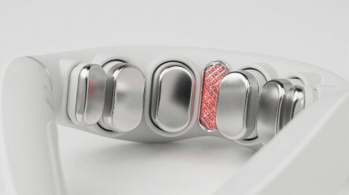 白いデバイスのクローズアップ写真。デバイスには、金属製のボタンと、おそらくLEDライトが付いた赤いグリッドのような部分があります。