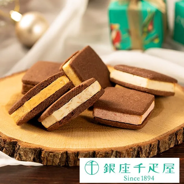 木製のまな板にチョコレートクッキーがいくつか並んでおり、ギフトボックスが背景