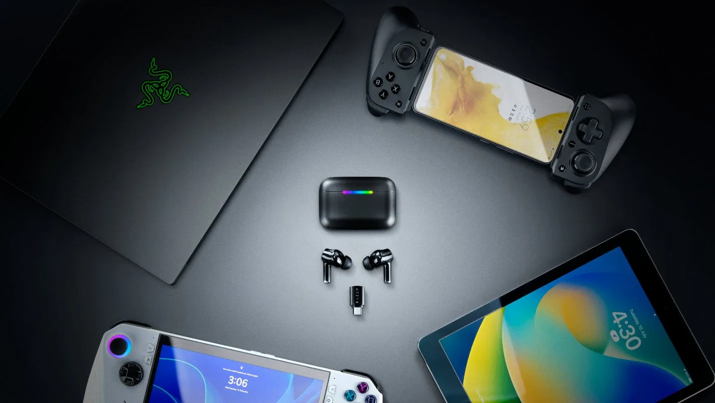 黒い背景に、ゲーミングデバイスが配置された写真。ノートPC、スマートフォン、タブレット、イヤホン、ゲームコントローラーなどが写っています。