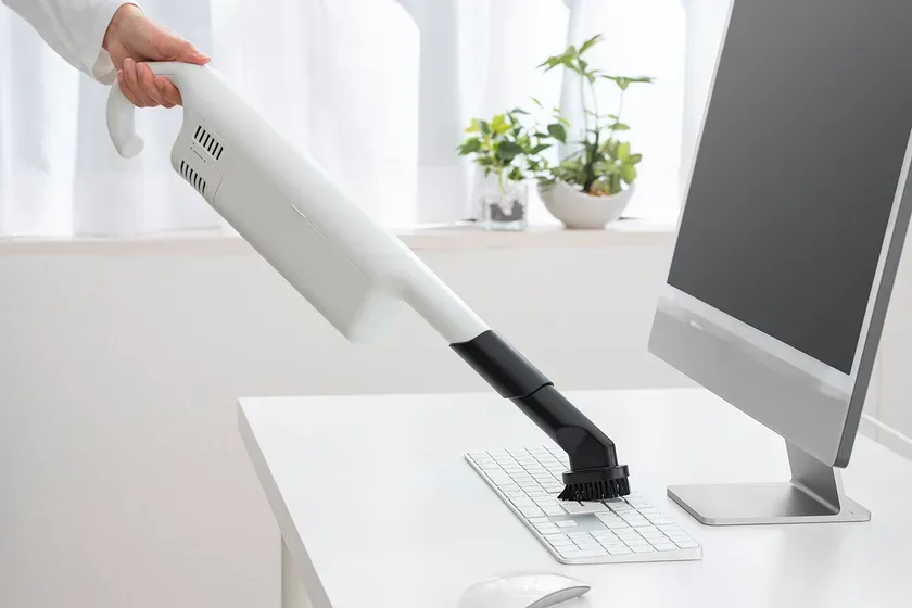 キーボードを掃除機で掃除している様子。