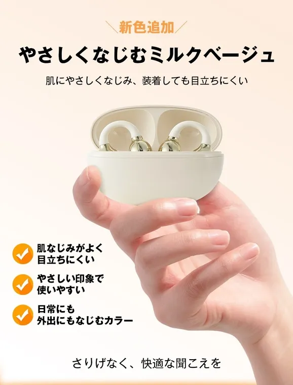 女性の手がイヤホンケースを持ち、イヤホンを取り出そうとしている画像。イヤホンはミルクベージュ色で、耳に優しい印象を与える。製品は「やさしくなじむミルクベージュ」というキャッチコピーで紹介され、肌なじみが良く、目立ちにくいことが特徴として強調されている。